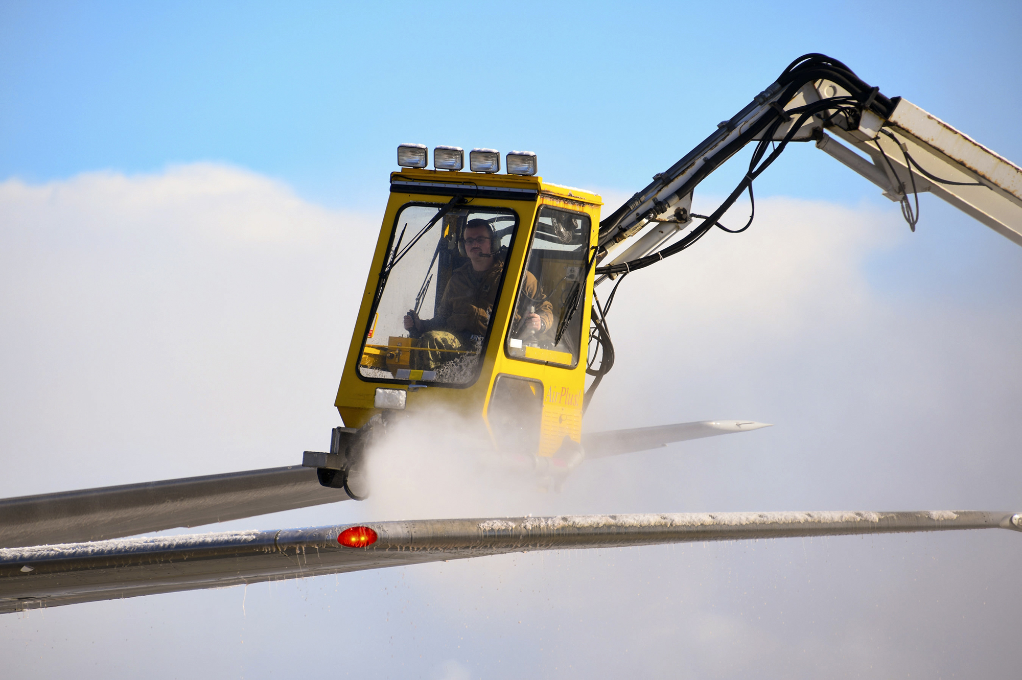 Aviation Machinist’s Mate 1st Class Andrew Sutton operates a de-icing truck to remove snow and ice from the wing of a P-8A Poseidon on Nov. 10, 2020, at Misawa Air Base.